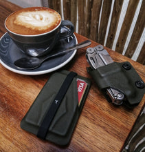 Load image into Gallery viewer, durable leatherman pouch and olive drab minimalist card holder next to cup of coffee